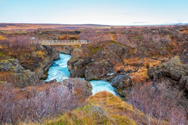 hay un puente sobre un río en medio de un cañón.