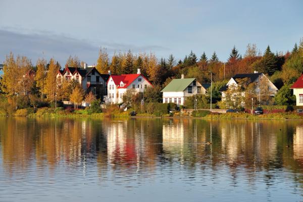 a row of houses sitting on the shore of a lake .