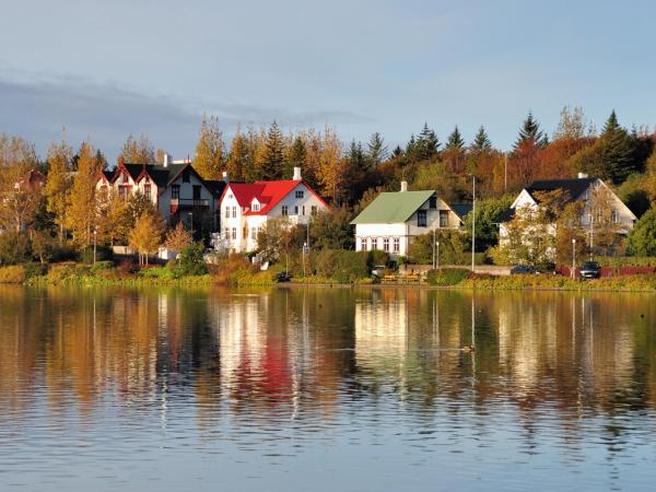 houses by a lake with autumn color trees
