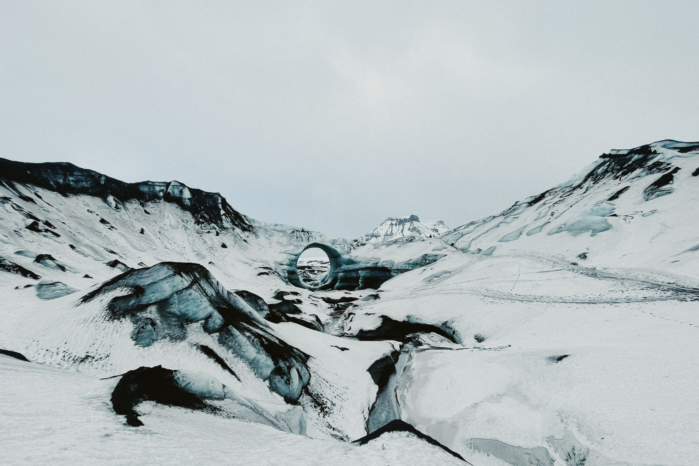 un paisaje montañoso nevado con un anillo en el centro de él.