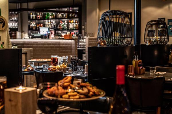 a restaurant with a bottle of wine and a plate of food on a table .Greifinn Restaurant in Akureyri Iceland