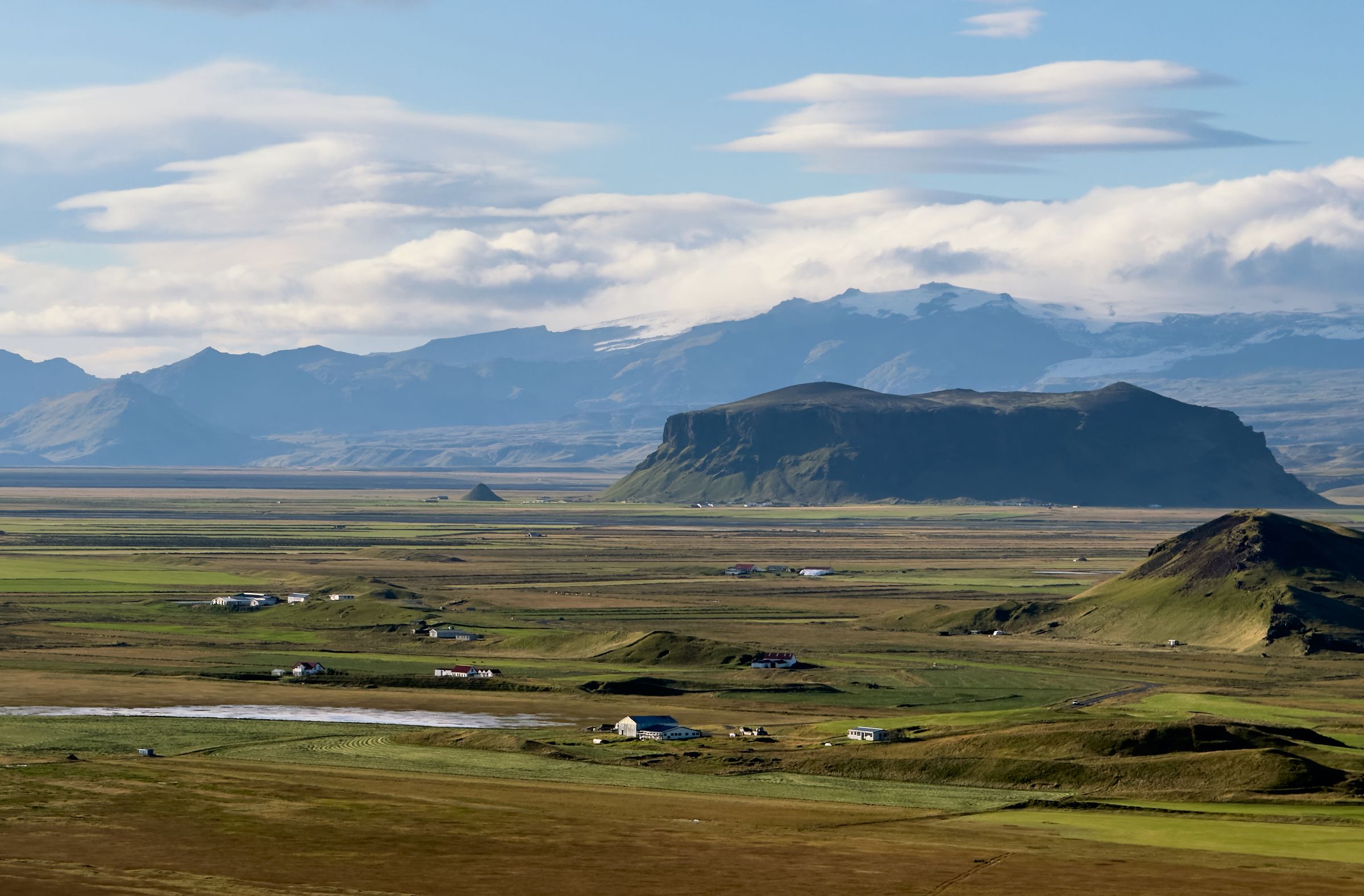 an aerial view of a valley with mountains in the background.