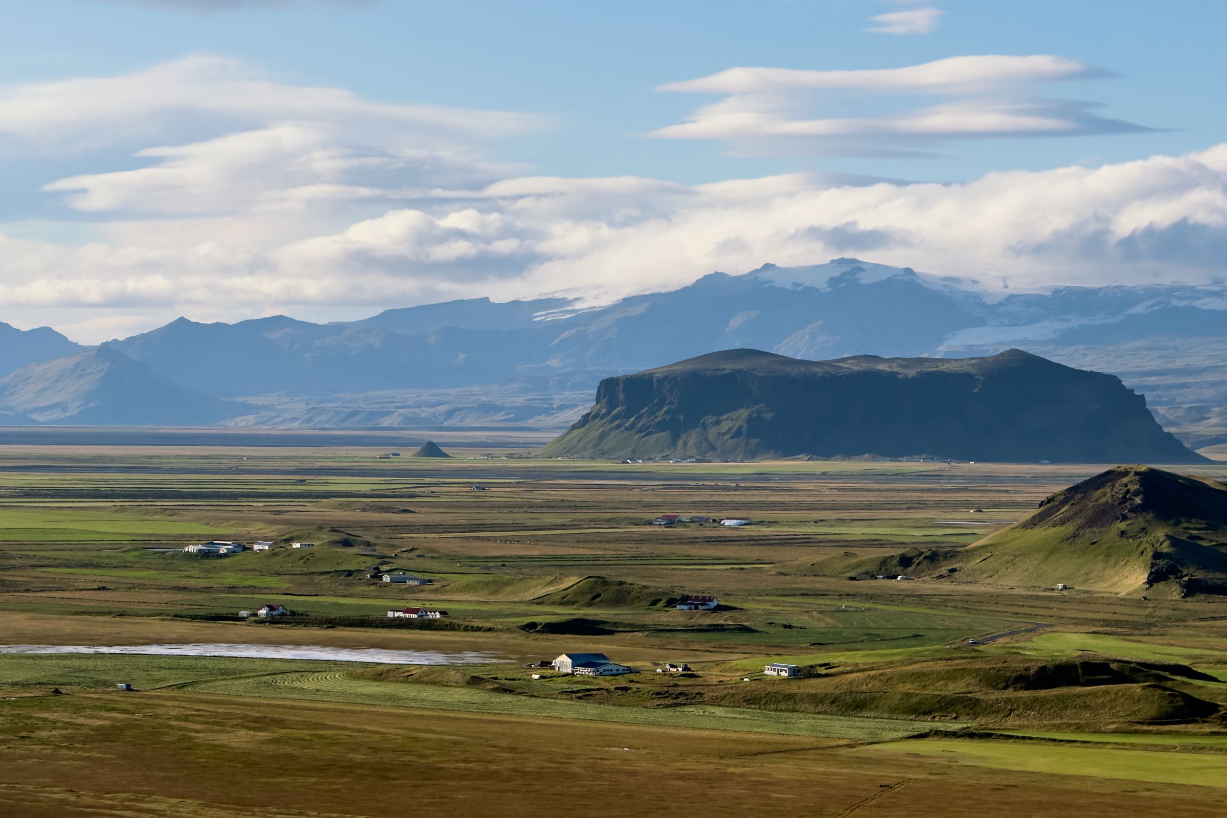 an aerial view of a valley with mountains in the background.