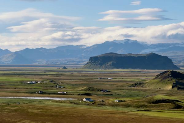 an aerial view of a valley with mountains in the background.