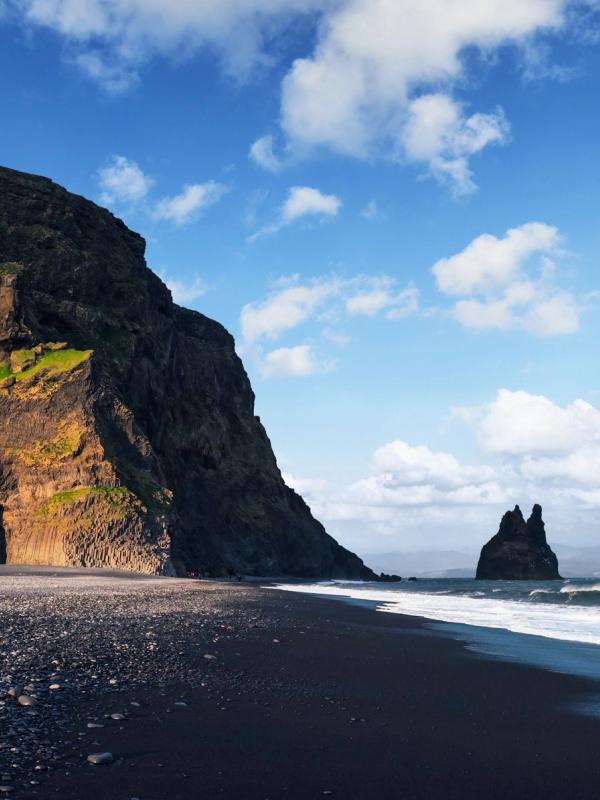 Reynisfjara a Black Sand Beach in Iceland on a blue sunny sky day