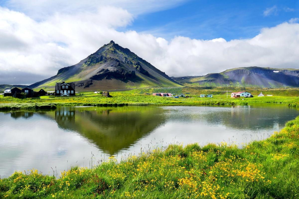 El pueblo Islandés de Arnarstapi con un pequeño lago y las montañas en el horizonte