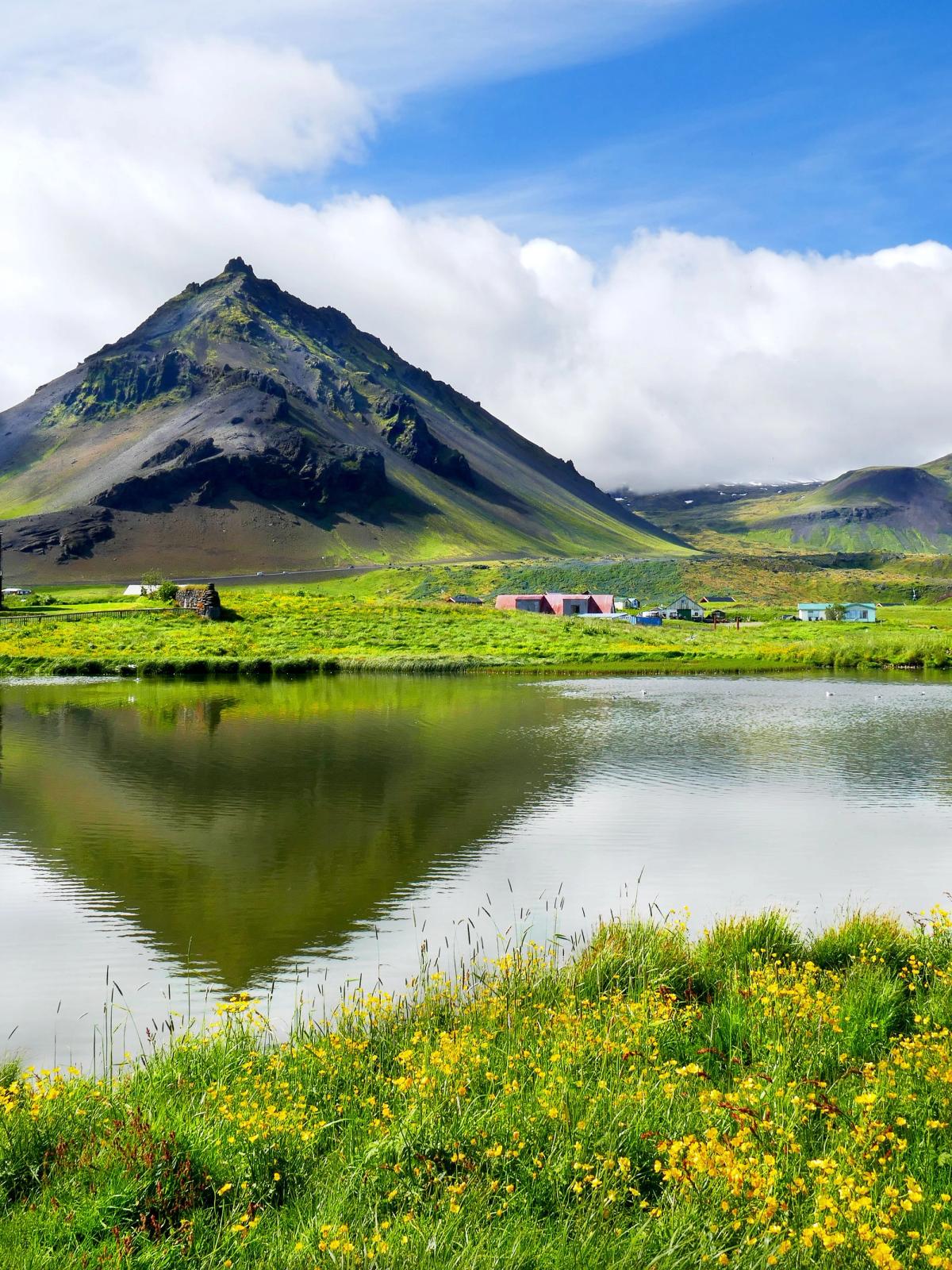 El pueblo Islandés de Arnarstapi con un pequeño lago y las montañas en el horizonte