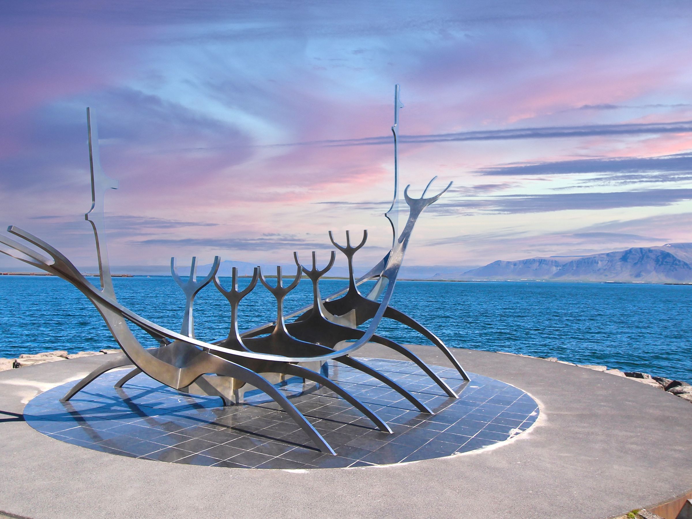 there is a statue of a boat in the middle of the ocean .