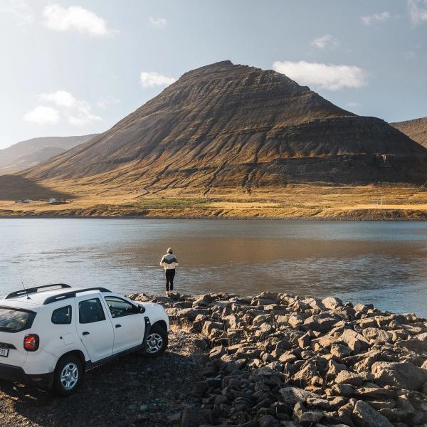 White SUV in front of a lake in Iceland