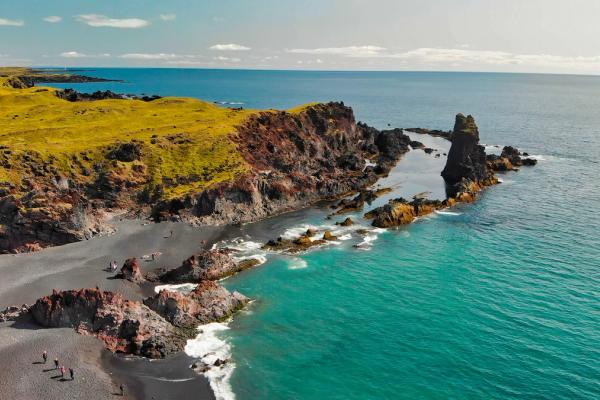 vista panorámica de la playa de Djupalonssandur beach con acantilados cubiertos de hierba verde