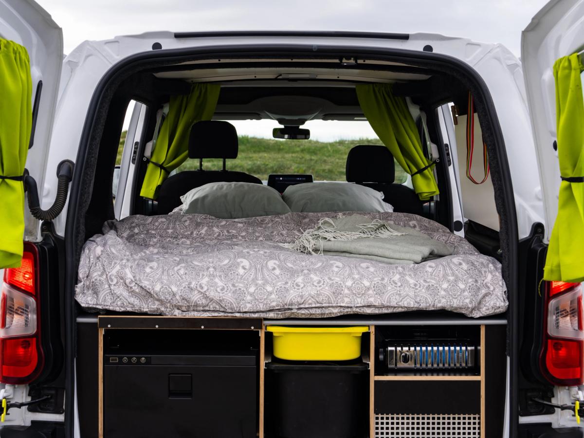 Cama accesible por las puertas traseras Las puertas traseras se abren y dan acceso a una cama con 2 almohadas, cortinas laterales y compartimentos de almacenamiento debajo.