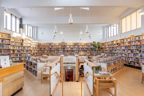 a large library filled with lots of books and chairs .