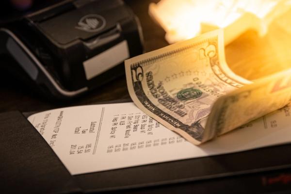 un billete encima de el ticket de una cuenta