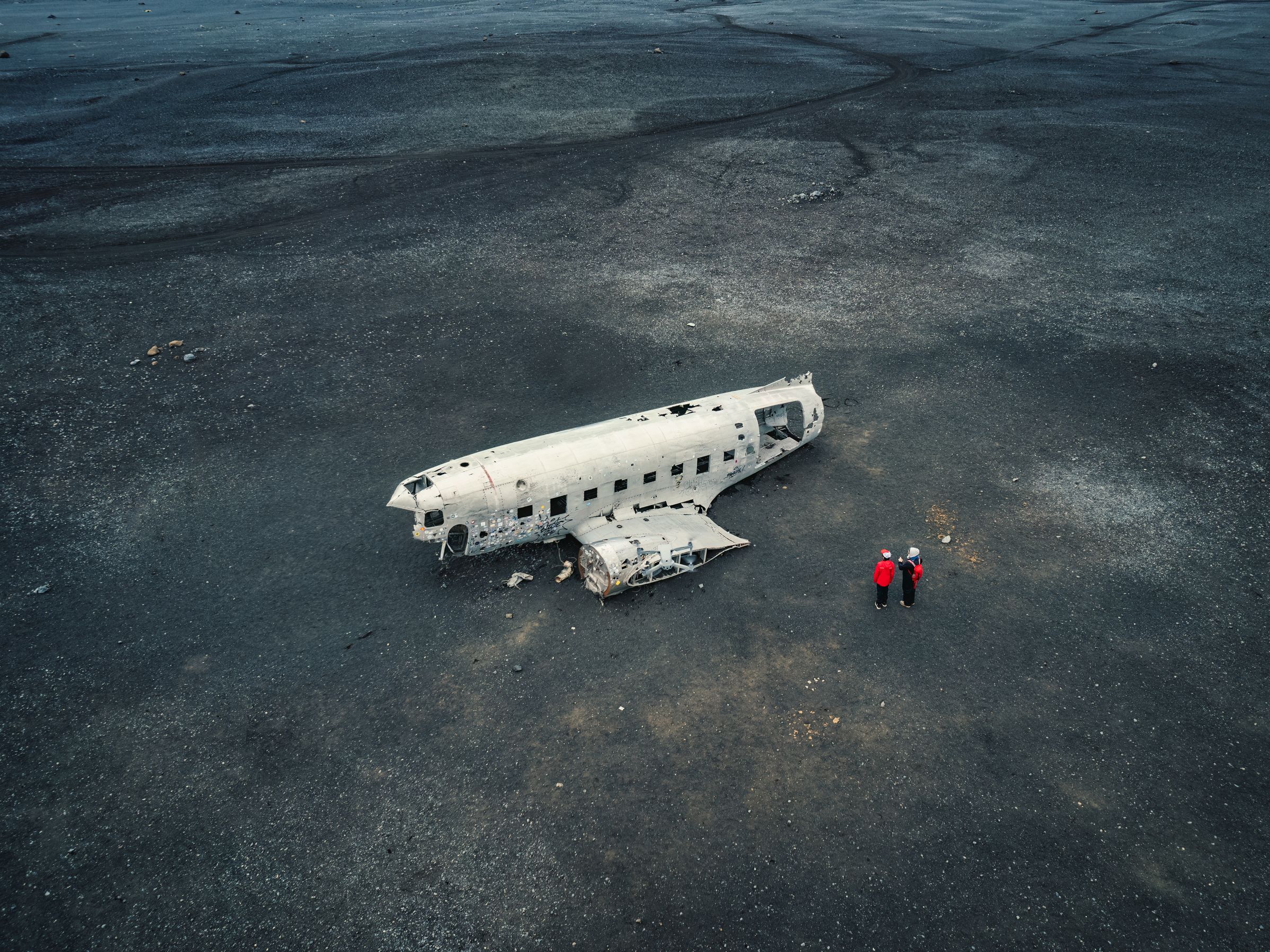 épave d'avion reposant sur une plage de sable noir