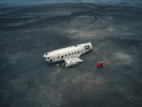 plane wreck sitting on a back sand beach