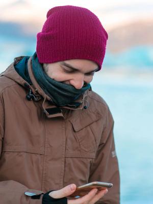 Tourist on an app Guy tourist walks in winter in Iceland. looking at his phone with an app open.