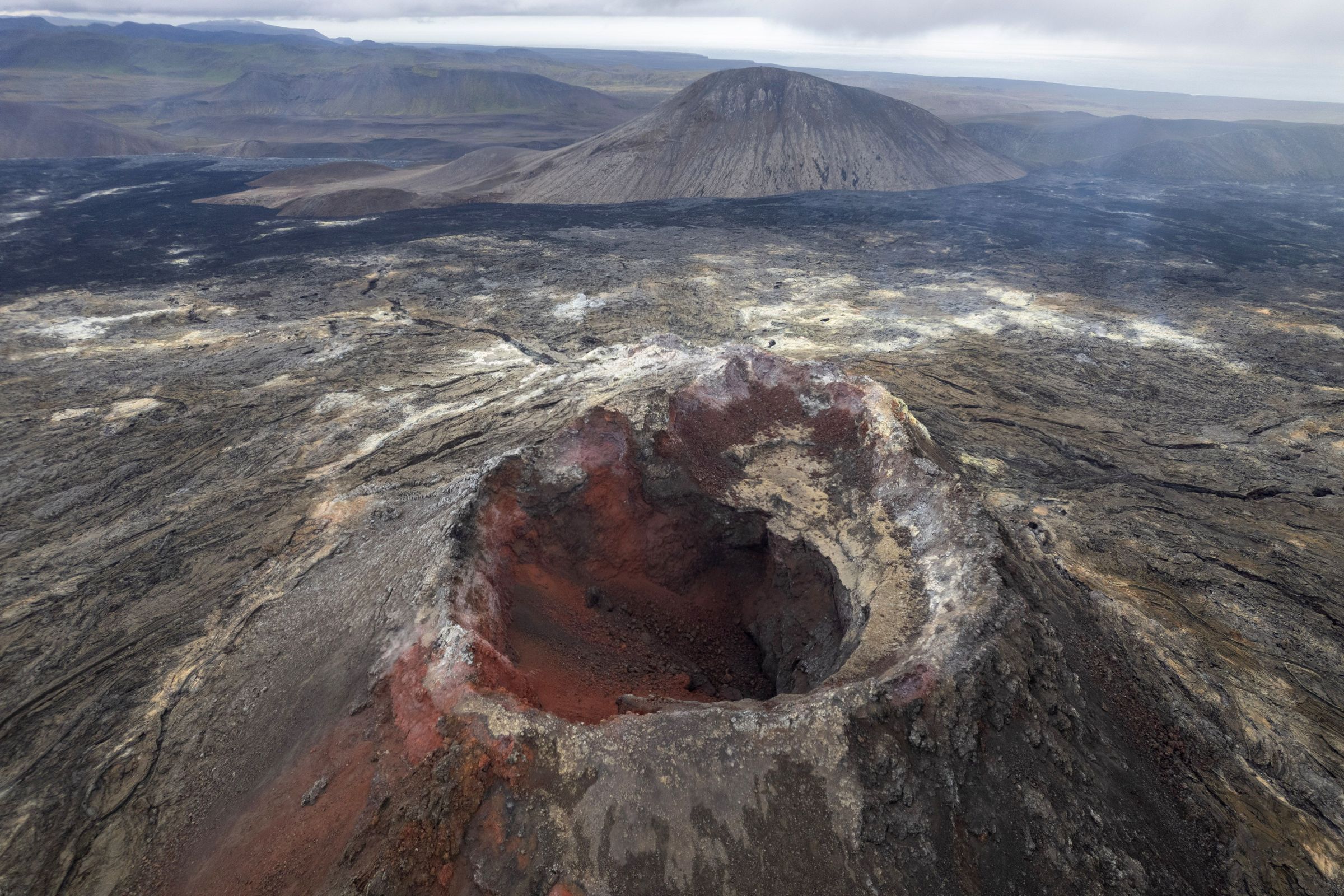 The Fagradalsfjall volcano, Iceland an aerial view of a volcano with a large crater in the middle of it .