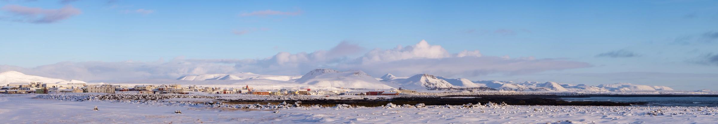 un campo nevado con montañas al fondo y un cielo azul