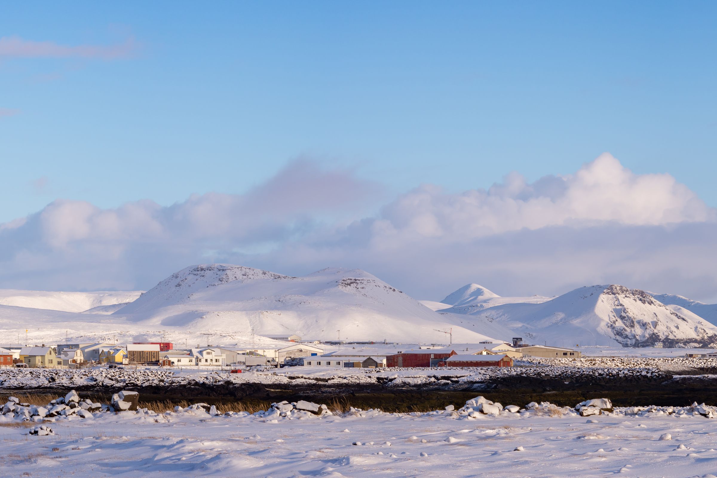 un campo nevado con montañas al fondo y un cielo azul