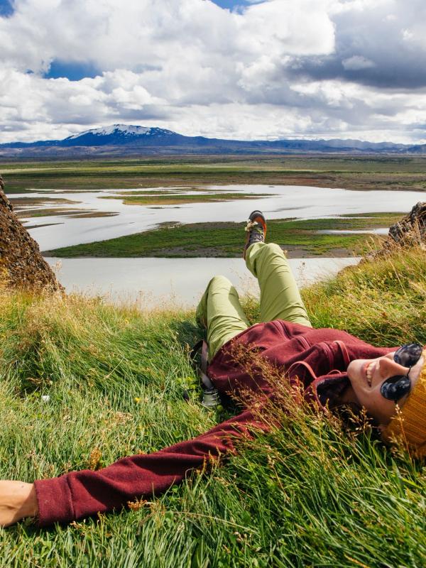 Happy young woman in bright clothes traveling Iceland, enjouing nature