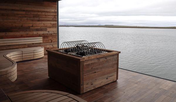 a wooden box is sitting on a wooden deck overlooking a body of water .