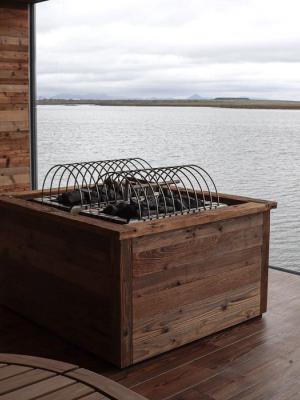 a wooden box is sitting on a wooden deck overlooking a body of water .