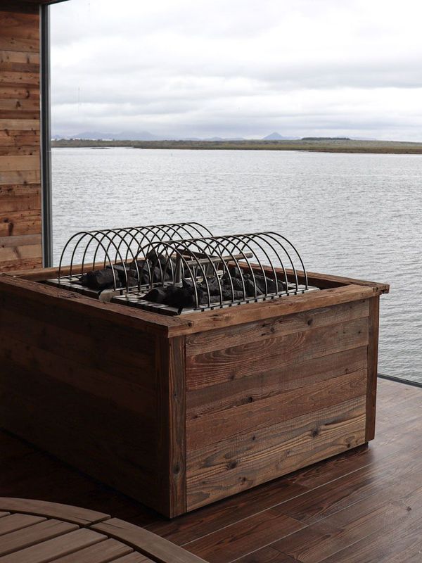 a wooden box is sitting on a wooden deck overlooking a body of water .