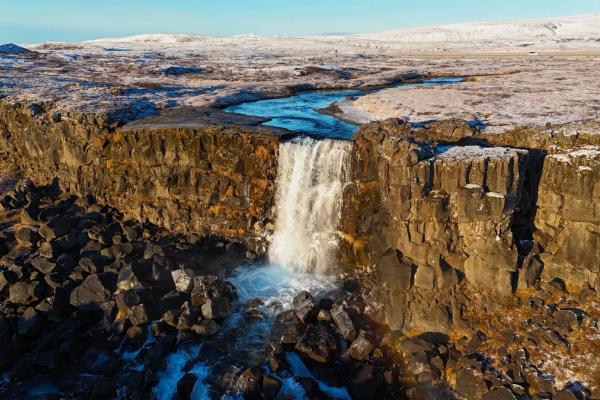 an aerial view of a waterfall in the middle of a rocky landscape .