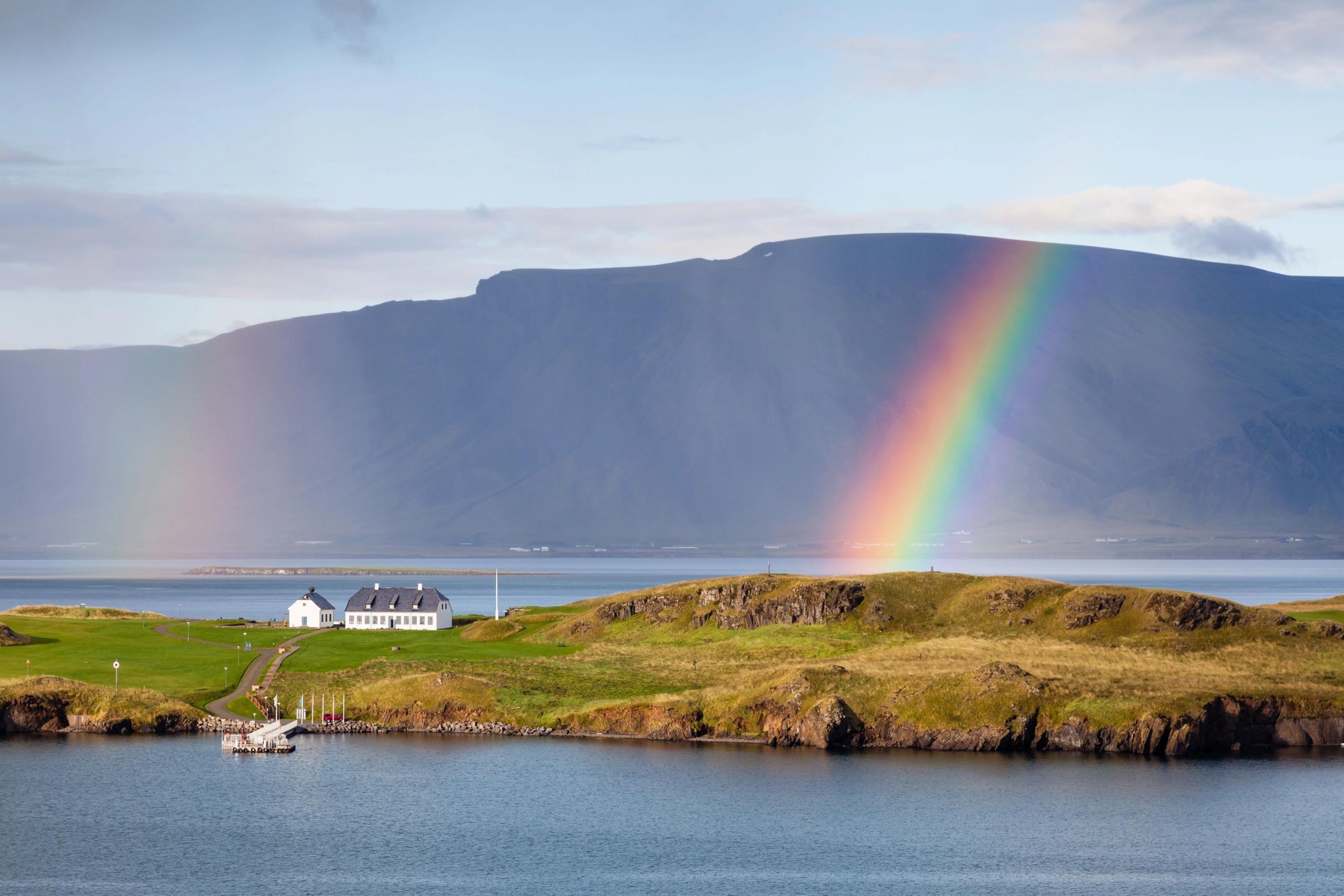 The view from Reykjavik harbour in Iceland as rain falls and a rainbow forms