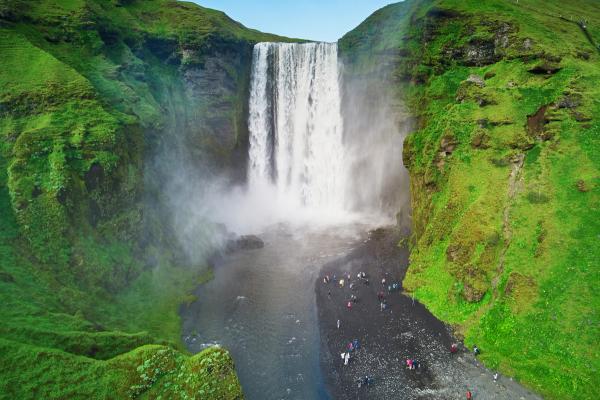 aerial view of a powerfull waterfall surrounded by green moss