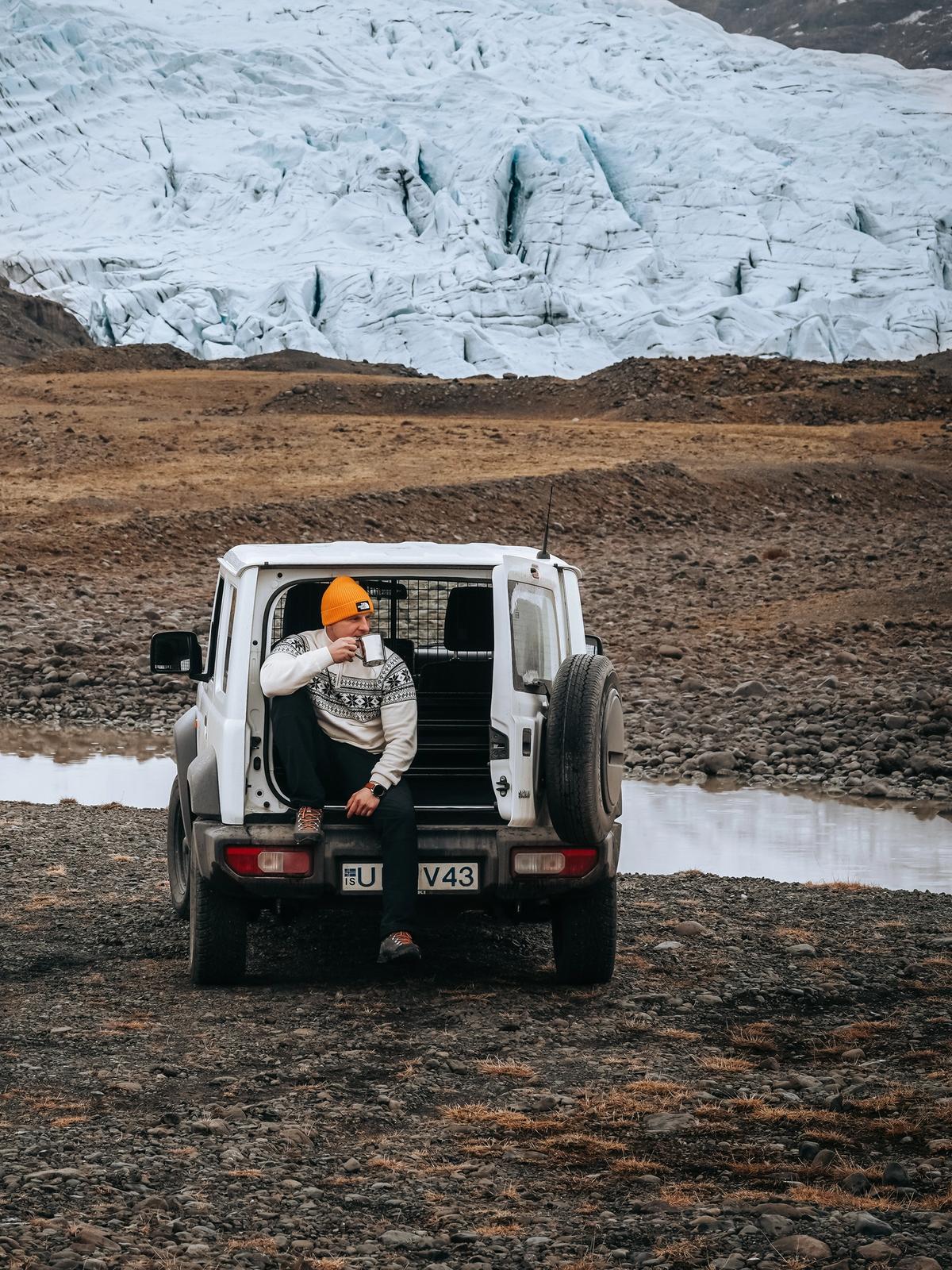 a man sits in the back of a white jeep with the license plate v43