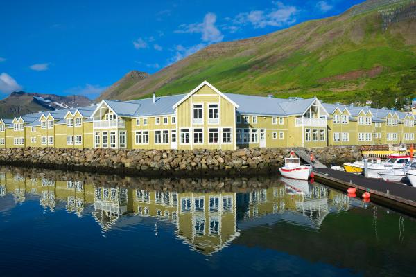 gran edificio de madera de color verdoso junto a un puerto en el mar