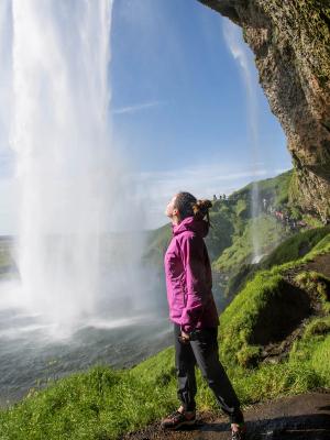 Woman behind Seljalandsfoss waterfall, Iceland