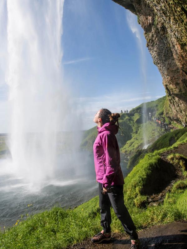Woman behind Seljalandsfoss waterfall, Iceland