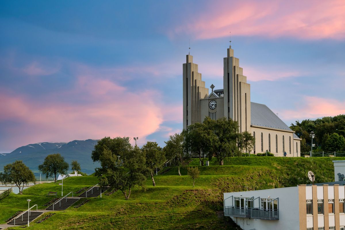 Una iglesia grande en lo alto de una colina repleta de césped
