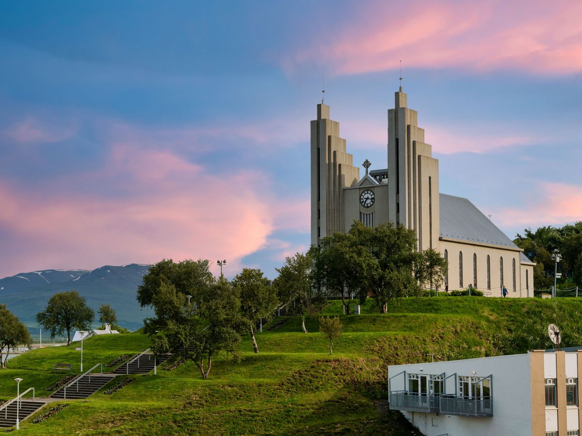 Una iglesia grande en lo alto de una colina repleta de césped