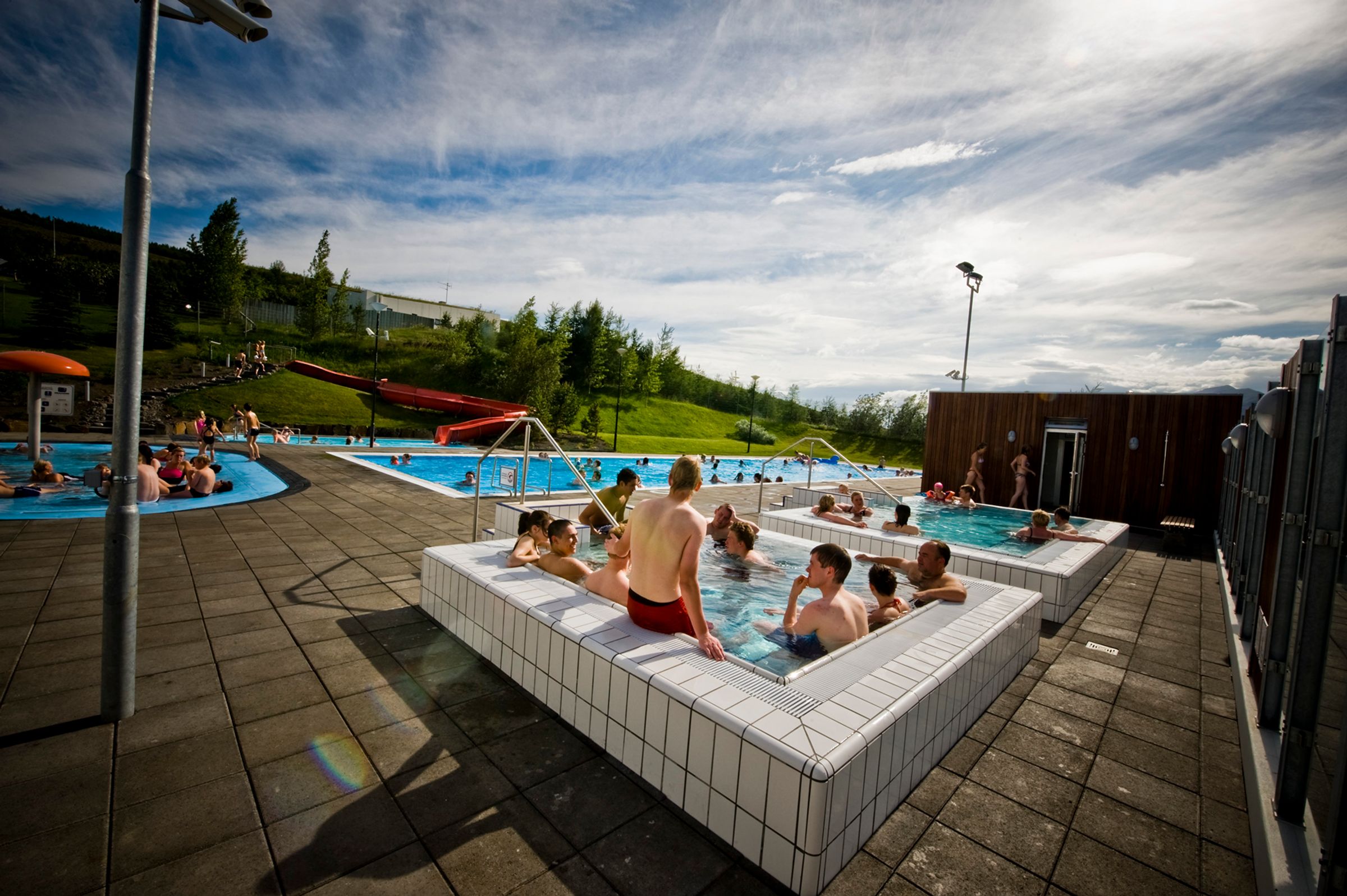 a group of people are sitting in a large swimming pool .