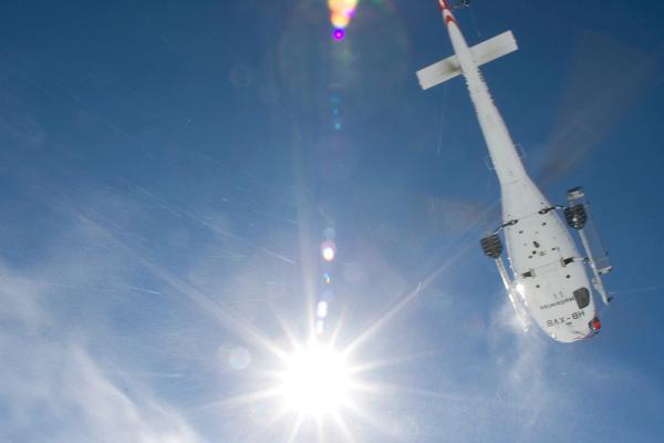 un helicóptero dejando a esquiadores en la nieve