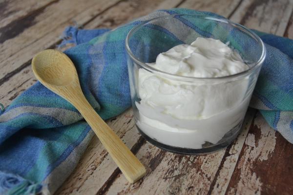 vaso de Skyr con una cuchara de madera fuera
