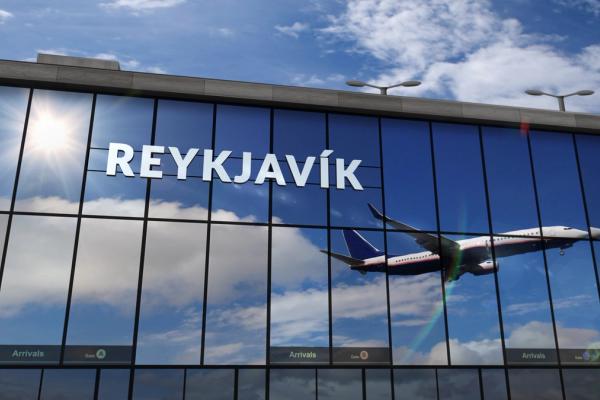 the reflection of a plane landing on an airport building