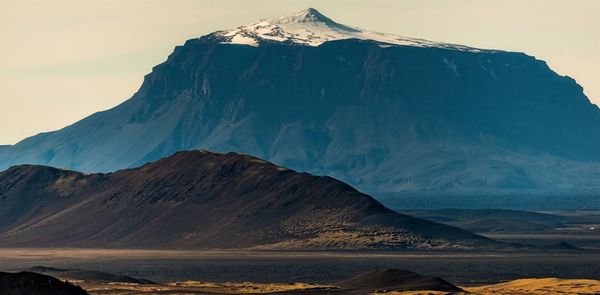 a large mountain covered in snow is surrounded by smaller mountains, Herðubreiðarlindir