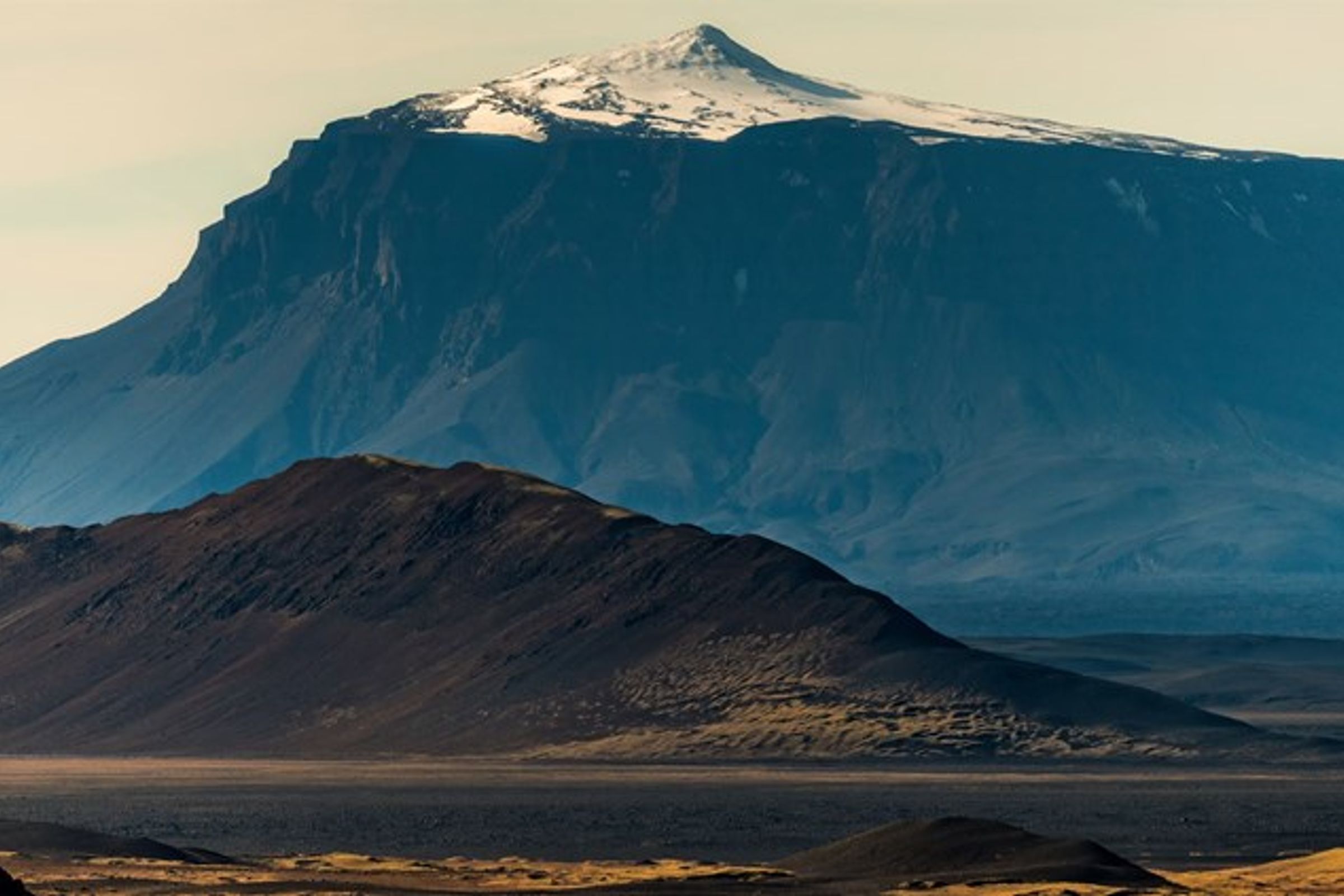 une grande montagne couverte de neige est entourée de montagnes plus petites, Herðubreiðarlindir