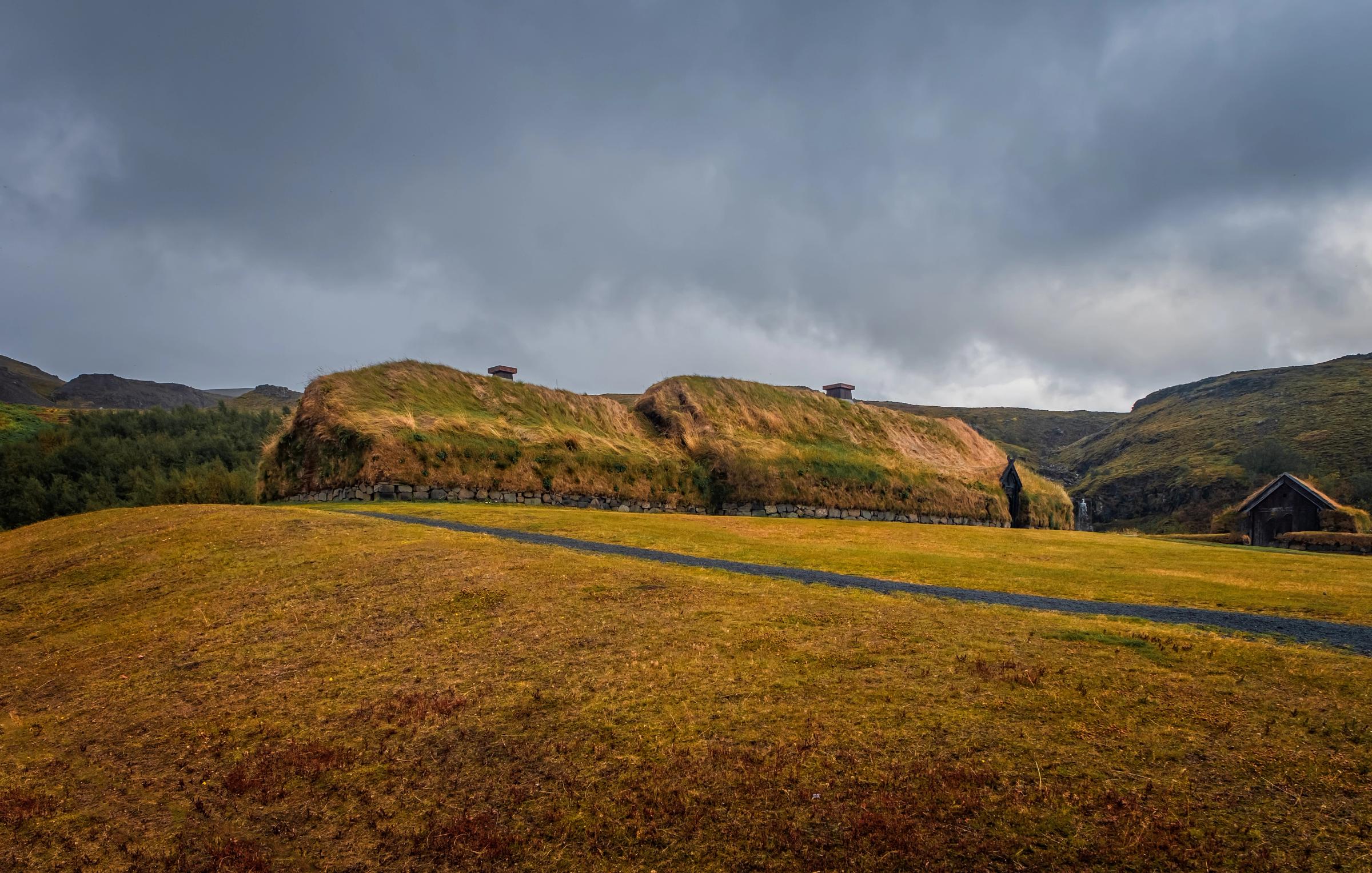 une maison est située au sommet d'une colline au milieu d'un champ .