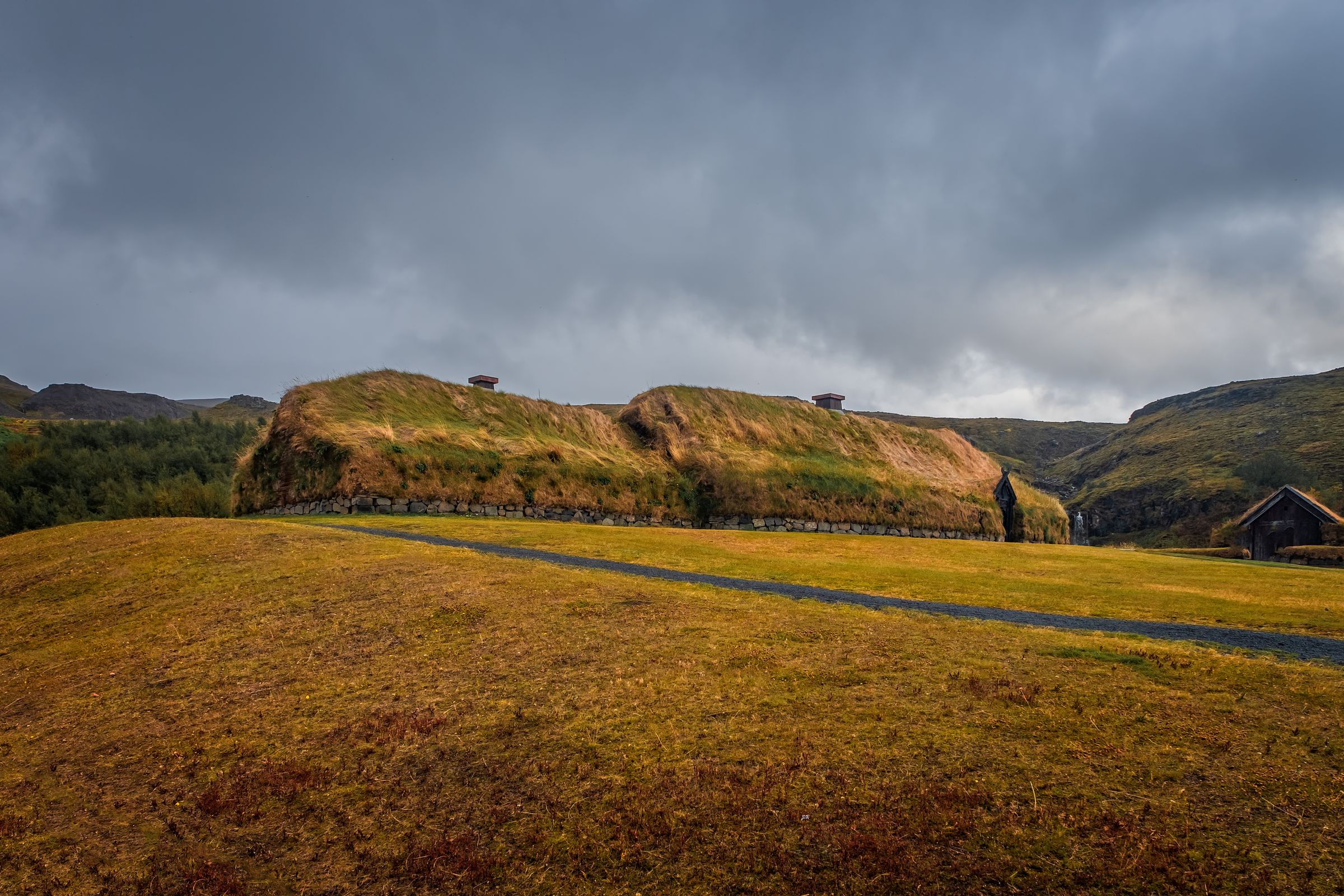 une maison est située au sommet d'une colline au milieu d'un champ .