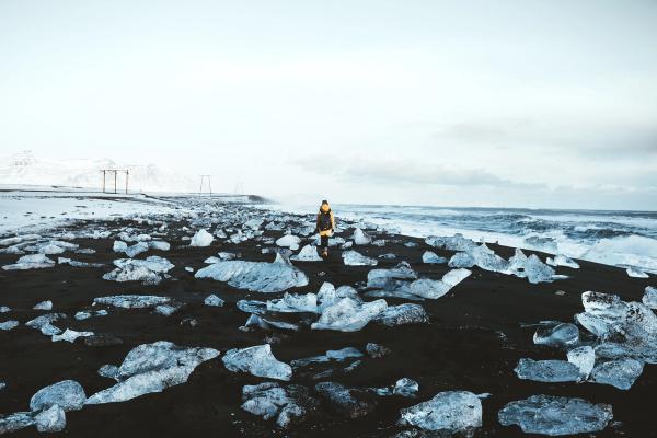 Hombre caminando por la Diamond Beach de Islandia