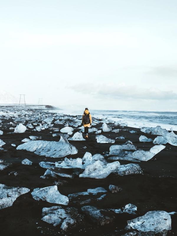 Hombre caminando por la Diamond Beach de Islandia