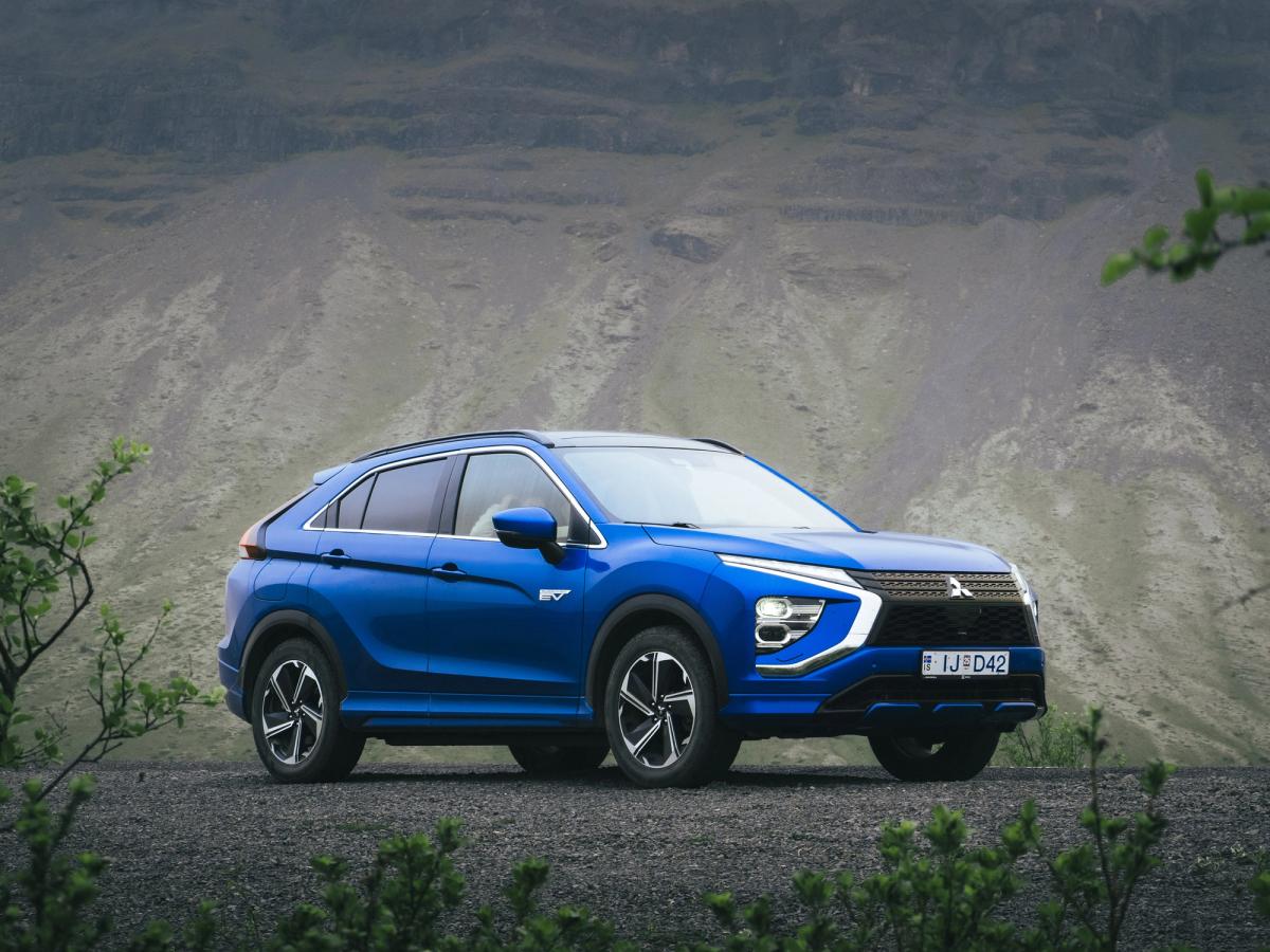 Mitsubishi Eclipse Cross Mountain View Mitsubishi Eclipse Cross aparcado sobre grava, rodeado de vegetación y con una ladera rocosa de montaña al fondo