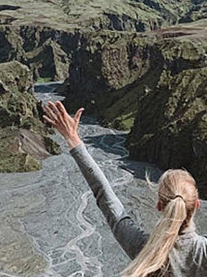 Mujer con los brazos arriba delante de unas montañas