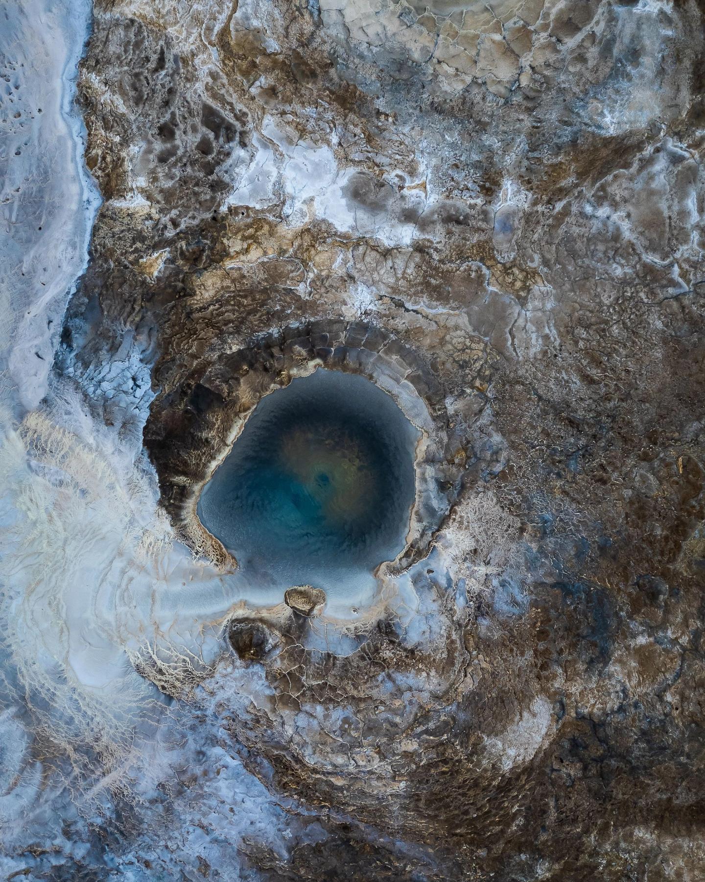 an aerial view of a large hole in the ground filled with water .