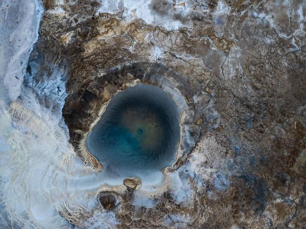 an aerial view of a large hole in the ground filled with water .
